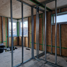 Innenraumaufnahme des Anbaus aus Holzrahmenbau. man sieht die OSB Lage der Außenwände, sowie das Gipskartonständerwerk der Innenwände