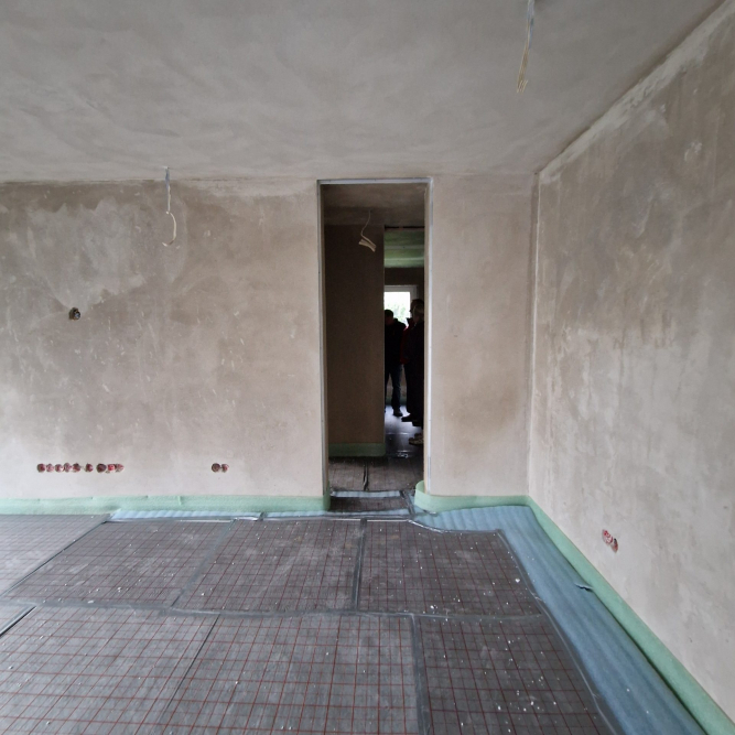 raumhohe Innentüröffnung. Innenputz fertiggestellt, Dämmung unter dem Estrich ausgelegt.