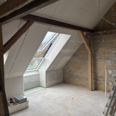 Dachgeschoss mit Estrich und fertig geschlossenen Dachschrägen aus Gipskarton.