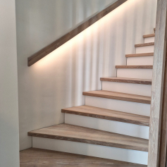 Treppe mit beleuchtetem Handlauf